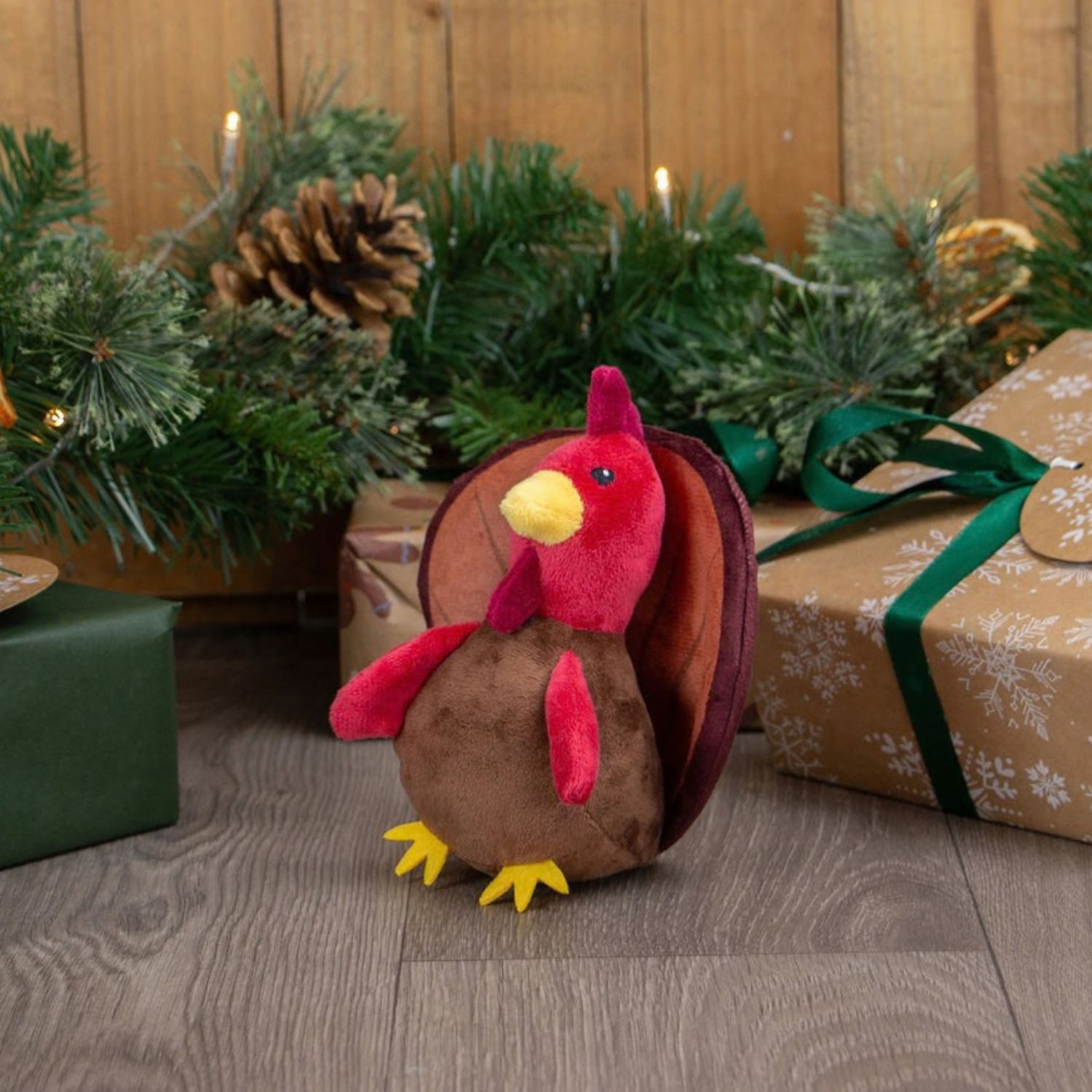 Ancol Mini Tina Turkey Christmas plush dog toy displayed outdoors with festive decorations